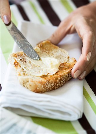 spreading butter on bread - Hands of woman spreading butter on toast Stock Photo - Premium Royalty-Free, Code: 6126-09102513