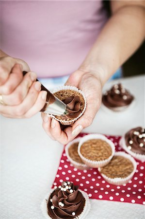 Hands of woman icing cupcakes in Sweden Stock Photo - Premium Royalty-Free, Code: 6126-09102518