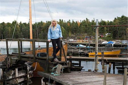 simsearch:6126-09103639,k - Young woman walking on wooden dock Stock Photo - Premium Royalty-Free, Code: 6126-09102679