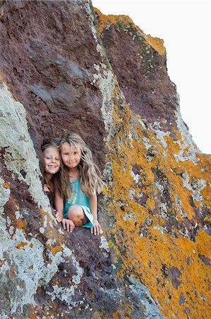 Two young girls looking out of a hole in the rocks Stock Photo - Premium Royalty-Free, Code: 6126-09102610