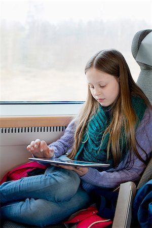 simsearch:6126-09104292,k - A young girl on a train playing on a tablet Photographie de stock - Premium Libres de Droits, Code: 6126-09102615