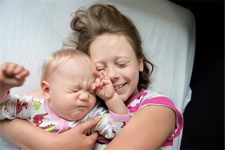 sister hugs baby - Girl lying down with her baby sister in Sweden Stock Photo - Premium Royalty-Free, Code: 6126-09102623
