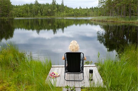 simsearch:6126-09102431,k - Woman sitting on jetty at lake side Photographie de stock - Premium Libres de Droits, Code: 6126-09102628