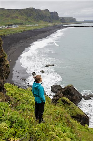 simsearch:6126-08636688,k - Hiker looking from cliff at black sand beach in Iceland Photographie de stock - Premium Libres de Droits, Code: 6126-09102743