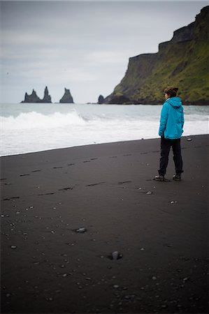 simsearch:6126-09102741,k - Hiker standing on black sand beach at feet of cliff in Iceland Stockbilder - Premium RF Lizenzfrei, Bildnummer: 6126-09102745