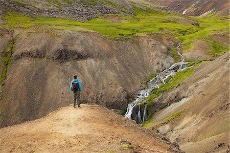 simsearch:841-08438554,k - Tourist looking at stream and waterfalls in rocky valley in Iceland Photographie de stock - Premium Libres de Droits, Code: 6126-09102725