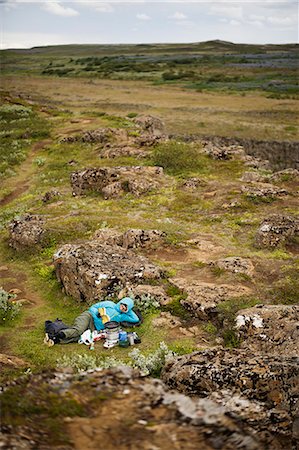 simsearch:6126-09104200,k - Hiker lying in rocky wilderness and reading book Photographie de stock - Premium Libres de Droits, Code: 6126-09102737