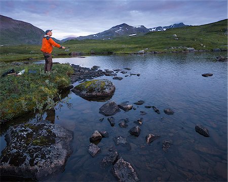 Man fishing in lake Sjuendevatnet at dawn Stock Photo - Premium Royalty-Free, Code: 6126-09102807