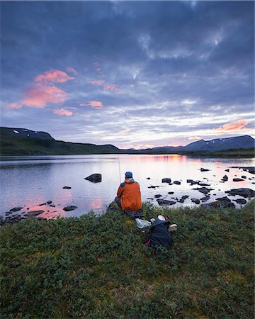 Man fishing in lake Sjuendevatnet at sunset Stock Photo - Premium Royalty-Free, Code: 6126-09102806