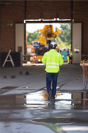 simsearch:6126-08644036,k - Man walking in construction site Stock Photo - Premium Royalty-Free, Code: 6126-09102980
