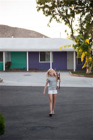 simsearch:6126-09102992,k - Girl carrying skateboard with motel in background Stock Photo - Premium Royalty-Free, Code: 6126-09102993