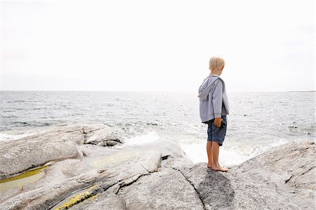 simsearch:6126-08635302,k - Boy standing on rocky seashore in the Stockholm archipelago Photographie de stock - Premium Libres de Droits, Code: 6126-09102917