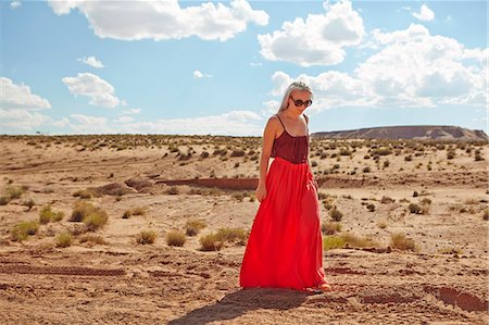 road trip in arizona - Young blonde woman wearing red skirt walking in desert, Arizona Stock Photo - Premium Royalty-Free, Code: 6126-09102934