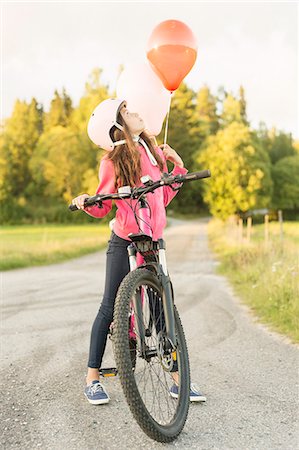 Girl riding bicycle at sunset Stockbilder - Premium RF Lizenzfrei, Bildnummer: 6126-09103090