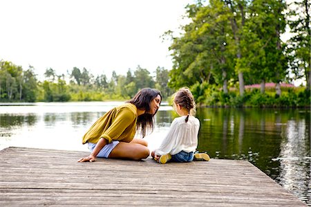 person by lake - Mother and daughter on pier beside lake in Friseboda, Sweden Stock Photo - Premium Royalty-Free, Code: 6126-09103039