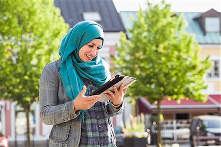 simsearch:6126-09104114,k - Muslim woman using tablet and smiling Photographie de stock - Premium Libres de Droits, Code: 6126-09103161