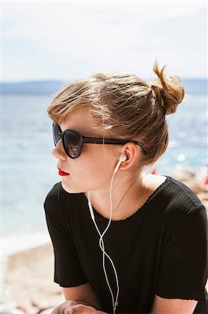 A young woman at the beach listening to music Stock Photo - Premium Royalty-Free, Code: 6126-09103187