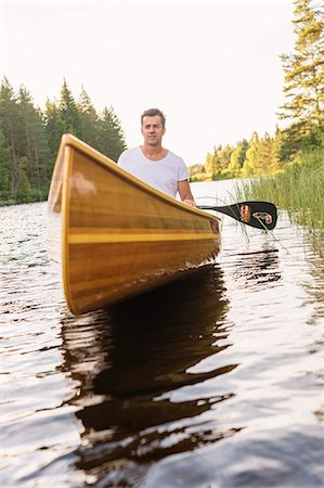 simsearch:6126-09102797,k - Man paddling on lake Foto de stock - Royalty Free Premium, Número: 6126-09103108