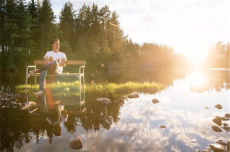 simsearch:6126-09102797,k - Man sitting on bench in middle of lake Foto de stock - Royalty Free Premium, Número: 6126-09103112