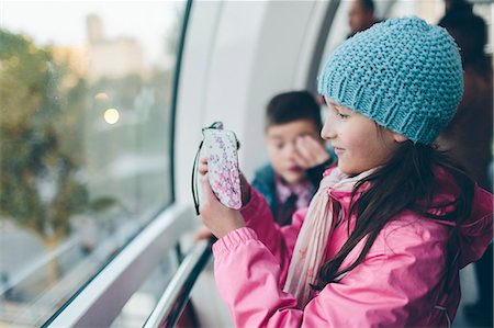 Girl taking pictures with smart phone and boy inside London Eye Foto de stock - Sin royalties Premium, Código: 6126-09103651