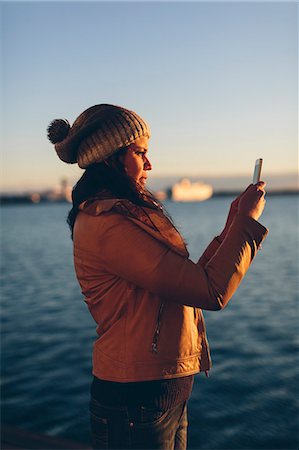 simsearch:6126-09103829,k - Woman holding a smart phone by the sea Stock Photo - Premium Royalty-Free, Code: 6126-09103682