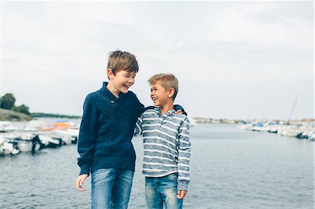 Boys standing next to marina and laughing Stock Photo - Premium Royalty-Free, Code: 6126-09103632