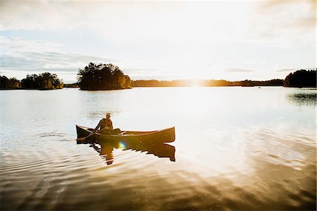 simsearch:6126-08635626,k - Mature man in boat on lake surrounded by forest Foto de stock - Royalty Free Premium, Número: 6126-09103750