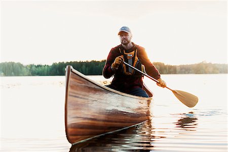 simsearch:6126-09104281,k - Man paddling canoe on lake Photographie de stock - Premium Libres de Droits, Code: 6126-09103725