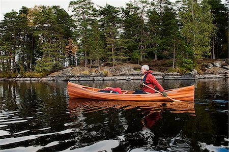 simsearch:6126-09102797,k - Man paddling canoe on lake Foto de stock - Royalty Free Premium, Número: 6126-09103733