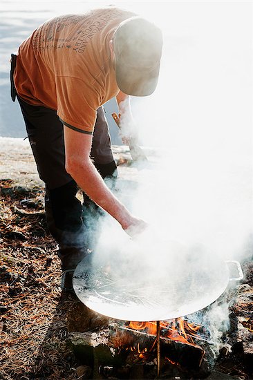 Man standing by fire Foto de stock - Sin royalties Premium, Código de la imagen: 6126-09103735