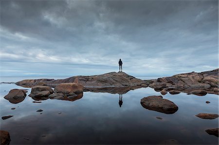 simsearch:6126-09266702,k - Woman standing on rock by a lake in Vasterbotten, Sweden Fotografie stock - Premium Royalty-Free, Codice: 6126-09103845