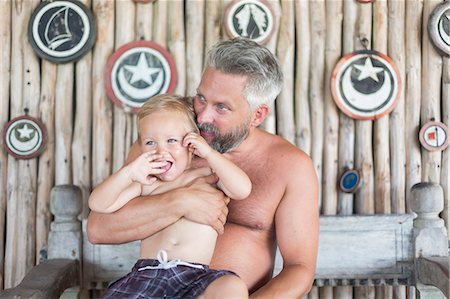 shack child - Mid adult man sitting with his son at Diani Beach, Kenya Stock Photo - Premium Royalty-Free, Code: 6126-09103898