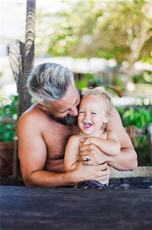 Mid adult man sitting with his son at Diani Beach, Kenya Stock Photo - Premium Royalty-Free, Code: 6126-09103900