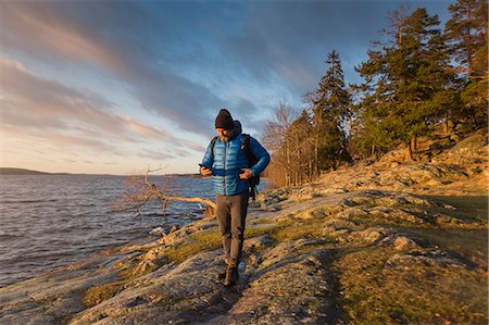 person by lake - Man walking along coastline in Jarfalla, Sweden Stock Photo - Premium Royalty-Free, Code: 6126-09103925