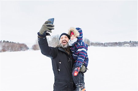 phone family selfie outside - Father taking selfie with son in snow Stock Photo - Premium Royalty-Free, Code: 6126-09103936