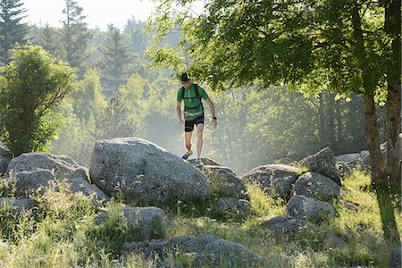 Man walking on rocks in the forest in Lozere, France Stock Photo - Premium Royalty-Free, Code: 6126-09104006