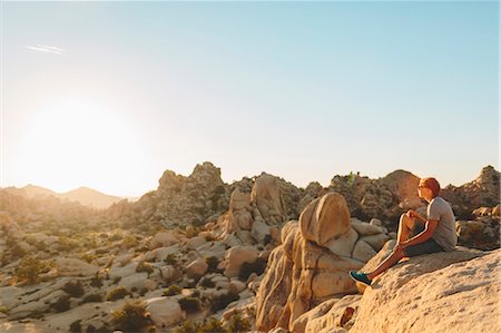 simsearch:6126-09102947,k - Man sitting on rock in Joshua Tree National Park and watching sunset Photographie de stock - Premium Libres de Droits, Code: 6126-09104202