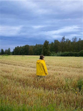 simsearch:6126-08644724,k - Woman wearing raincoat standing in field Foto de stock - Sin royalties Premium, Código: 6126-09104238