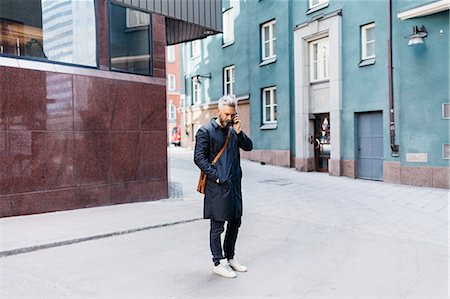 pic of a navy man - Man on smart phone on street in Stockholm, Sweden Stock Photo - Premium Royalty-Free, Code: 6126-09104376
