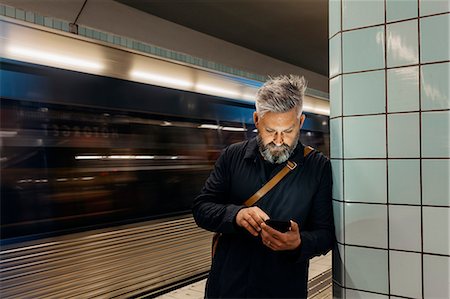 simsearch:6126-09204310,k - Man texting at train station in Stockholm, Sweden Photographie de stock - Premium Libres de Droits, Code: 6126-09104378