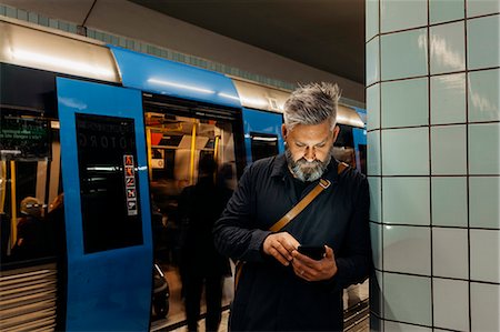 simsearch:6126-09204310,k - Man texting at train station in Stockholm, Sweden Photographie de stock - Premium Libres de Droits, Code: 6126-09104379