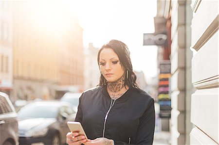 simsearch:6126-09103925,k - Woman holding a smart phone on a street in Stockholm Stock Photo - Premium Royalty-Free, Code: 6126-09104303