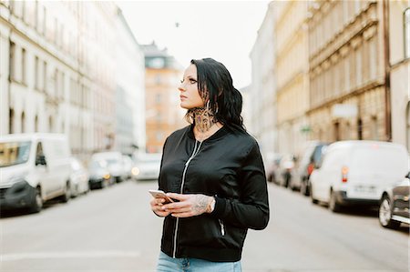 simsearch:6126-09204310,k - Woman holding a smart phone on a street in Stockholm Photographie de stock - Premium Libres de Droits, Code: 6126-09104301