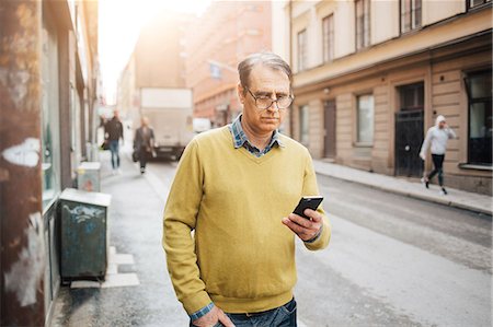 simsearch:6126-09267293,k - Man holding a smart phone on a street in Stockholm Stock Photo - Premium Royalty-Free, Code: 6126-09104313