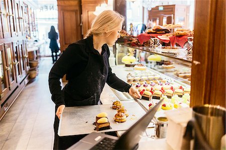 simsearch:6126-09104476,k - Baker putting baked goods in display window in Sweden Stock Photo - Premium Royalty-Free, Code: 6126-09104496