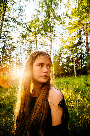 simsearch:6126-08636151,k - Portrait of young woman in forest at sunset Stockbilder - Premium RF Lizenzfrei, Bildnummer: 6126-09266482