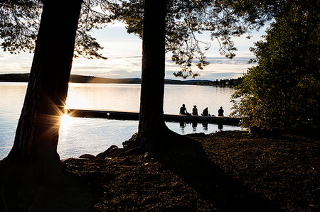 silhouette people sitting on a dock - Young woman on the pier of a lake in Dalarna Sweden Foto de stock - Sin royalties Premium, Código: 6126-09266556