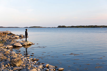 simsearch:6126-09266702,k - Man standing on rocks near sea in the Saint Anna Archipelago, Sweden Fotografie stock - Premium Royalty-Free, Codice: 6126-09266657