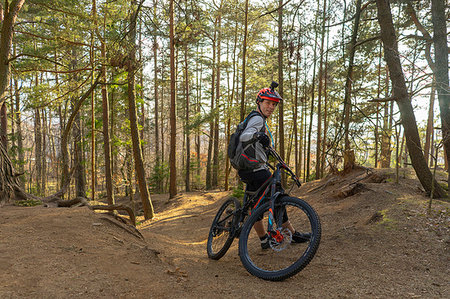 simsearch:6126-09267379,k - Mid adult man leaning on mountain bike in a forest Photographie de stock - Premium Libres de Droits, Code: 6126-09267194