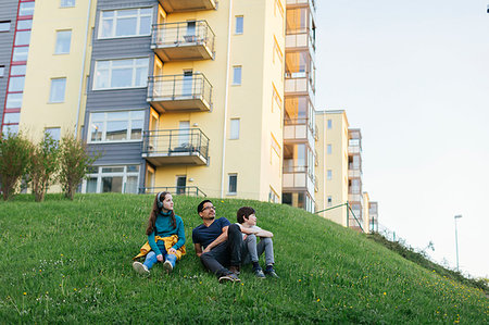simsearch:6126-09104323,k - Father and his children sitting on lawn by apartment building Foto de stock - Sin royalties Premium, Código: 6126-09267257
